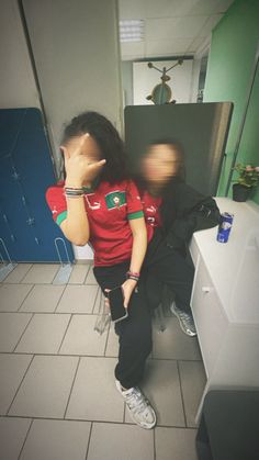 a woman sitting on top of a counter next to a sink