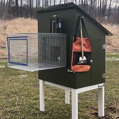 a bird house with a cage on top in the grass