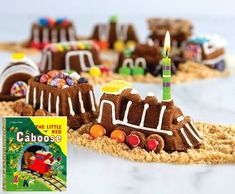 there is a cake shaped like a train on the tracks with a candle in it