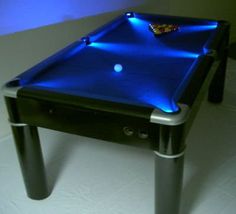 a pool table that is lit up with blue lights on the top and bottom edge