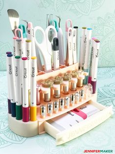 a cupcake holder with pens, scissors and markers