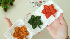 crocheted shamrock appliques are being held by someone's hand