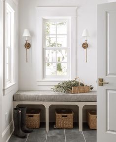 a white room with a bench and some baskets