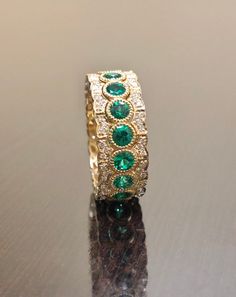 DeKara Designs Collection Metal- 18K Yellow Gold, .750. Stones- 17 Genuine Round Emeralds 1.90 Carats, 102 Round Diamonds F-G Color VS1 Clarity 0.42 Carats. Entirely Handmade 18K Yellow Gold Eternity Diamond Round Emerald Engagement Band. This band is extremely elegant featuring round fiery, and beautiful green emeralds that are all professionally burnish set individually with amazing bead work surrounding each stone. There are 51 professionally pave set round diamonds on the top and bottom of b Emerald Wedding Jewelry With Pave Setting, 6th Wedding Anniversary, Engagement Band, Gold Art Deco, Emerald Engagement, Engagement Bands, Art Deco Diamond, Diamond Wedding Band, Gold Art