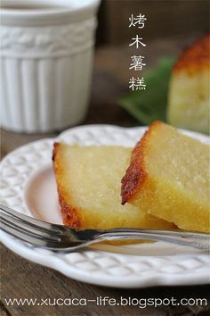 two pieces of cake on a white plate with a fork and cup in the background