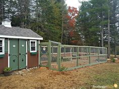 a fenced in area with a small shed and chicken coop on the other side