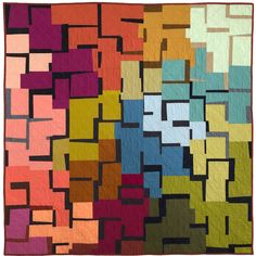 a colorful quilt is hanging on the wall