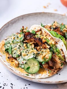 two tacos filled with vegetables and sauce on a plate