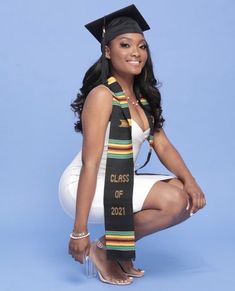 a woman in a graduation cap and gown is posing for a photo with her graduate's sash