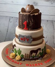 a three tiered cake decorated with cowboy themed decorations