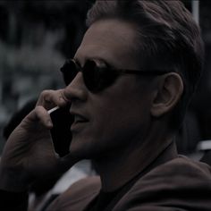 a man in sunglasses talking on a cell phone