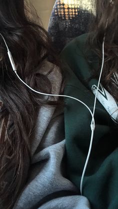 a woman laying on top of a couch wearing headphones with her hair blowing in the wind