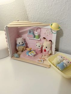 there is a toy house with many small animals in it and toys on the table