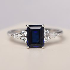 All HANDMADE ITEMS SHIP IN APPROX 8 DAYS Main Stone: Lab created sapphire Main Stone Size: Emerald cut 6 mm x 8 mm Main Stone Weight: 1.75 carat Side Stone: CZs Height From The Ring Setting Bottom(to gemstone top): about 5.13 mm Width of Ring band Measure: gradually varied,about 1.67 to 1.91 mm Material: .925 Sterling Silver/14K White Gold/14K Yellow Gold/14k Rose Gold Engraved: Available For FreeNo more than 13 letters) Customized:Of course! Tell me what you want Includes With Order: All of my Sapphire Engagement Ring Silver Band, Elegant Octagon Diamond-cut Sapphire Ring, Elegant Octagon Diamond Cut Sapphire Ring, Classic Silver Sapphire Ring With Radiant Cut, Lab-created Emerald Cut Sapphire Ring With Prong Setting, Classic Emerald Cut Sapphire Birthstone Ring, Elegant Sapphire Ring With Square Cut And Prong Setting, Emerald Cut Lab-created Sapphire Ring With Prong Setting, Elegant Sapphire Ring With Emerald Cut