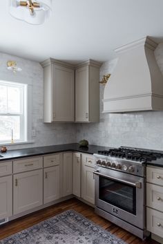 a kitchen with an oven, stove and rug in the middle of the flooring