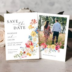 two wedding cards with flowers on them are sitting next to each other in the grass