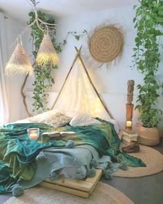 a bedroom with plants and lights on the wall, bedding is covered in blankets