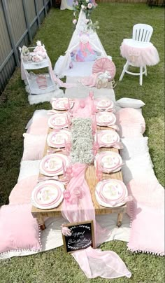 a table set up with pink and white plates