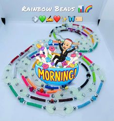 an image of a rainbow bead necklace with the words morning on it and a cartoon character