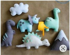 felt dinosaurs are arranged on a brown surface