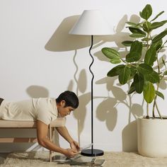 a man laying on the floor next to a table with a laptop in front of him