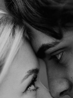 black and white photograph of a man kissing a woman's forehead with her eyes closed