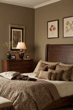 a bedroom with a bed, dresser and lamp on the side table in front of it