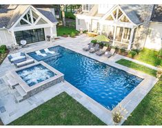 an aerial view of a backyard with a pool and hot tub in the foreground