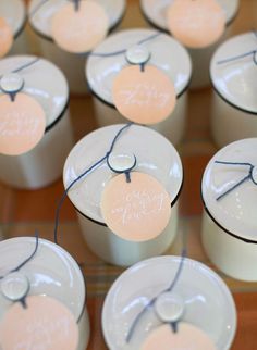 many small cups with labels on them are sitting on a table together in the shape of hearts