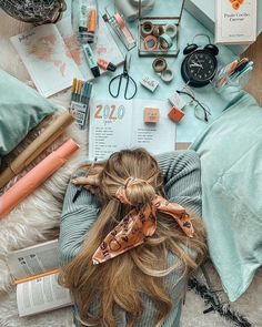 a woman laying on the floor with her hair in a pony tail tied to her head