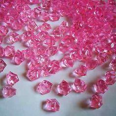 pink crystals are scattered on a white surface