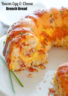 a meatloaf bundt cake is cut in half on a white plate with green garnishes