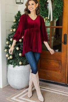 This velvet tunic is so cute and comfy! That fabric is wonderfully luxurious and we love that casual fit. This tunic is going to look equally good with jeans and leggings. It all just depends on the occasion you are wearing it too. V-neckline 3/4 sleeves with elastic cuffs Smocked detailing along the shoulders Velvet fabric Generous stretch Savannah is wearing the small. Red Festive Tunic Blouse, Festive Red Tunic Set, Red Bohemian Tunic Top, Velvet Tunic Plus Size, Red Long Sleeve Cotton Tunic, Velvet Tunic, Casual Fits, Velvet Fabric, Dark Red