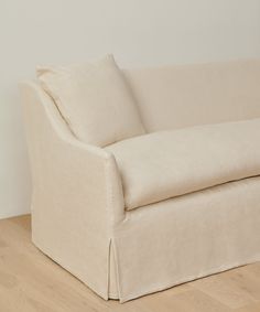 a white couch sitting on top of a hard wood floor