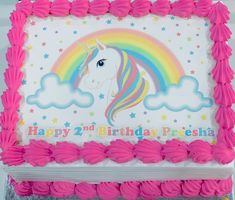 a birthday cake with pink frosting and a rainbow on it