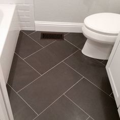 a white toilet sitting next to a bath tub in a bathroom