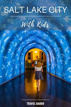 a woman walking through a tunnel with the words salt lake city with kids