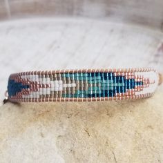 a beaded bracelet sitting on top of a rock