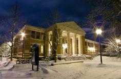 a snowy night in front of a large building