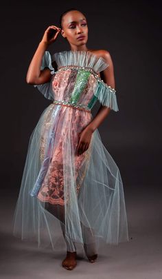 a woman in a dress and sandals poses for the camera