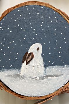 a painting of a dog in the snow on a piece of wood with white and brown paint