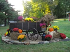 a wagon filled with flowers and pumpkins sitting on top of a field