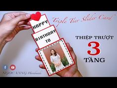 a person holding up a birthday card with the number three tag attached to it in front of a white background