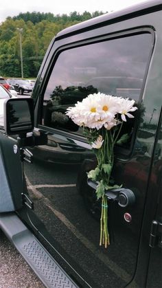 a bouquet of flowers is placed in the back of a pickup truck's door