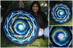 a woman is holding up a large piece of art that looks like a circular object