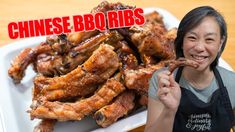 a woman holding up a piece of meat with the words chinese bbq ribs on it