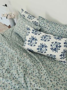 a blue and white floral comforter set on a bed with matching pillowcases