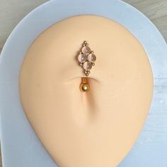 a mannequin head with an earring made out of gold and pink beads