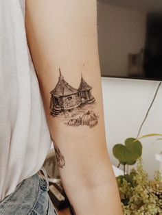 a woman's arm with a small black and white drawing of a house on it