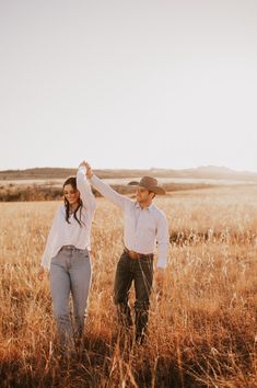 a man and woman standing in the middle of a field